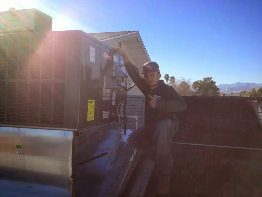 HVAC technician performing AC Tune-Up on a rooftop unit in Dormont